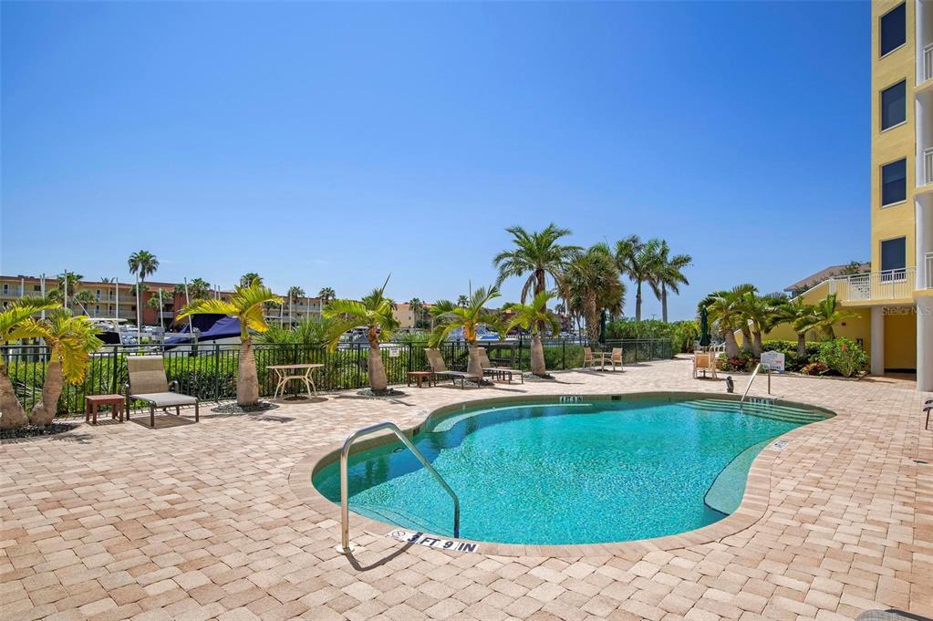 9122 Midnight Pass Road, Unit 34 Sarasota, FL 34242 - Photo 47 of 61 a swimming pool with outdoor seating and yard in back