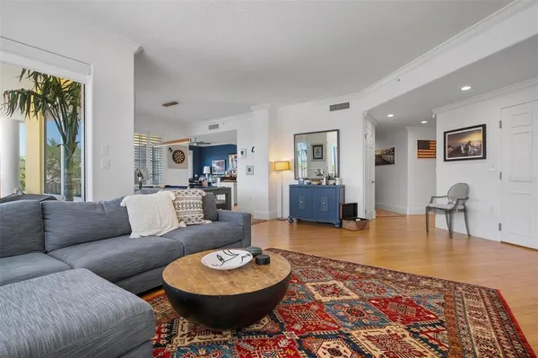 a living room with furniture a wooden floor and next to a window