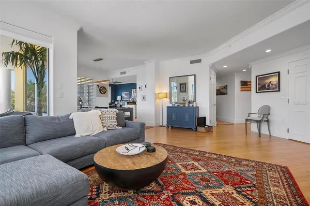 a living room with furniture a wooden floor and next to a window