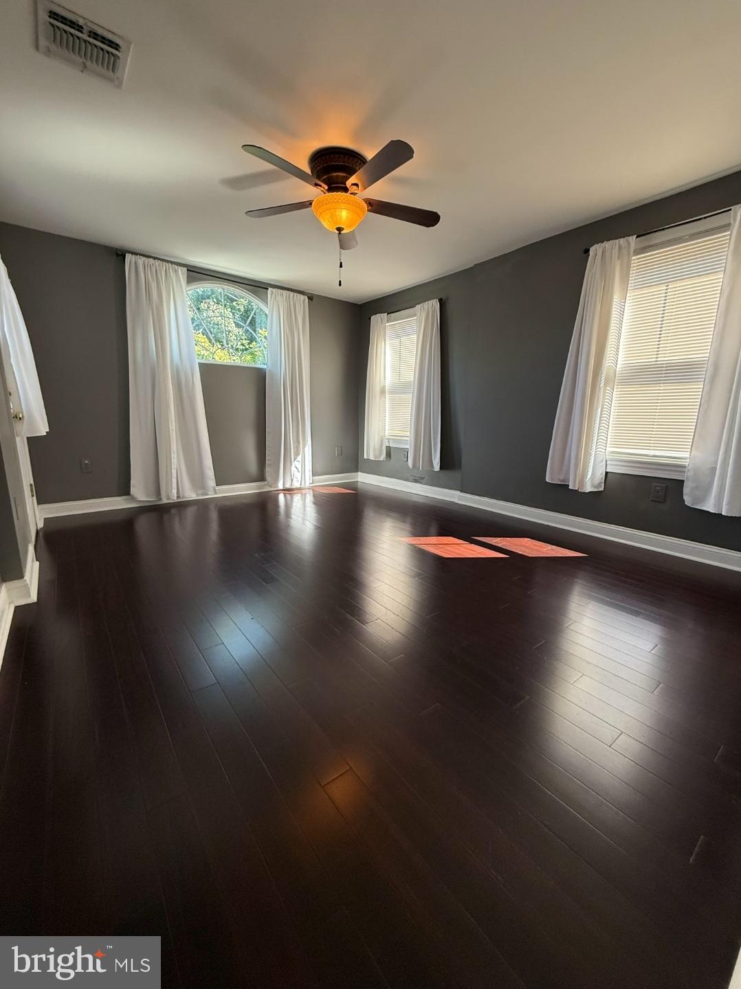 21 East Avenue, Unit B Woodstown, NJ 08098 - Photo 4 of 10 a view of an empty room with wooden floor and a window