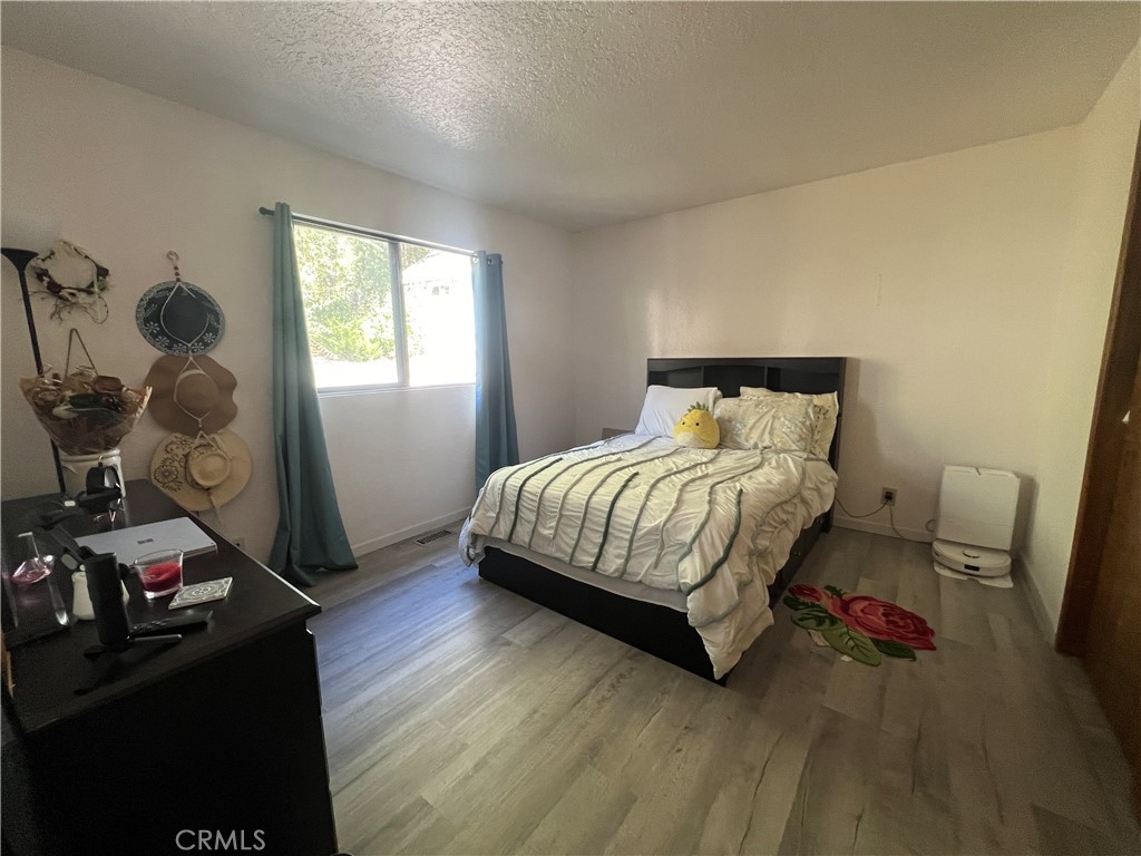 23857 Zuger Drive Crestline, CA 92325 - Photo 14 of 29 a bedroom with a bed and wooden floor