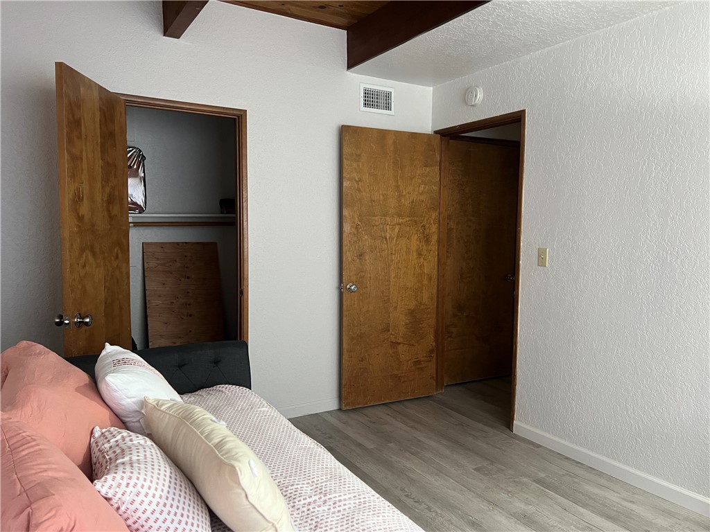 23857 Zuger Drive Crestline, CA 92325 - Photo 23 of 29 a bedroom with a bed and wooden floor