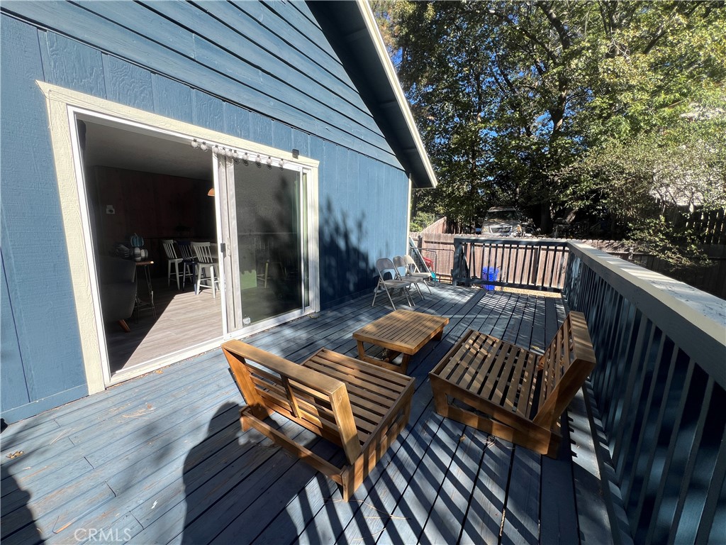 23857 Zuger Drive Crestline, CA 92325 - Photo 26 of 29 a view of a patio with table and chairs with wooden floor and fence