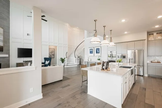 a large white kitchen with a large window and stainless steel appliances