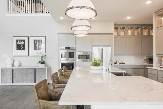 a large kitchen with kitchen island a large counter space stainless steel appliances and cabinets