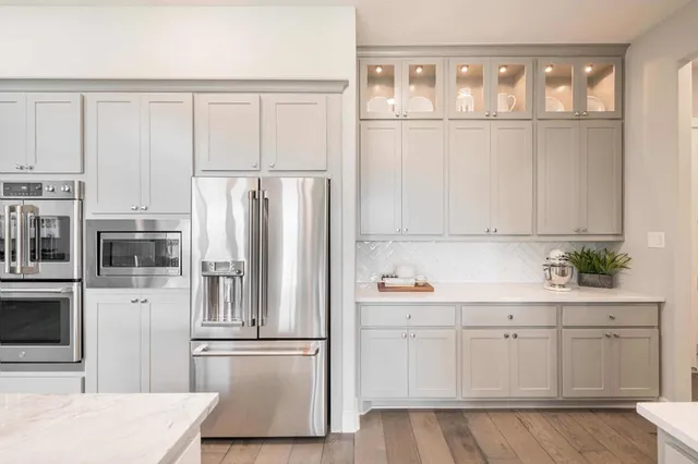 a kitchen with white cabinets and refrigerator