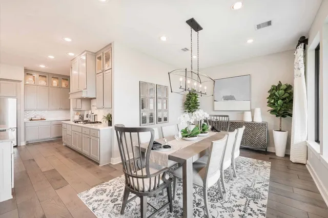 a view of a dining room and livingroom with furniture wooden floor a chandelier