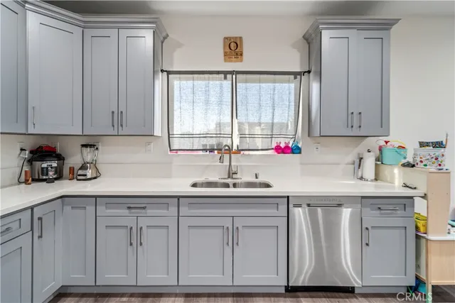 a kitchen with white cabinets and sink