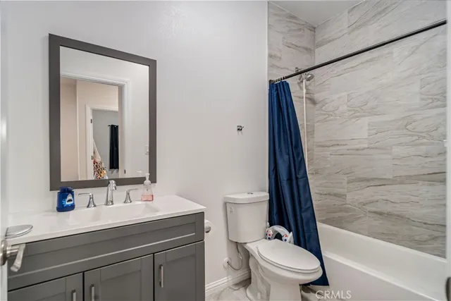 a bathroom with a sink a toilet a mirror and shower