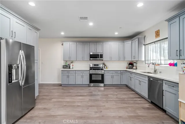 a large kitchen with cabinets stainless steel appliances and a window