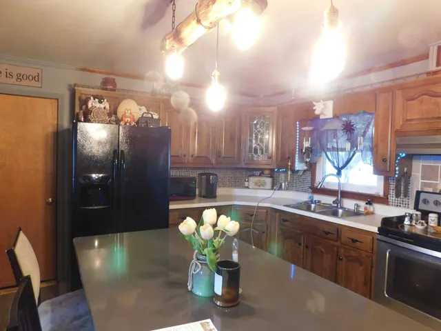 a kitchen with stainless steel appliances kitchen island granite countertop a stove a sink and a cabinets