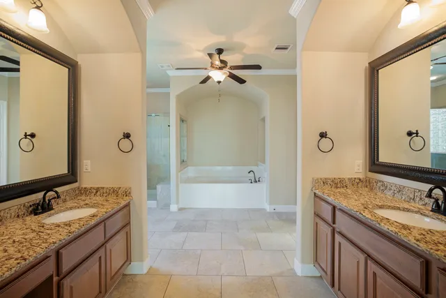 a bathroom with a granite countertop sink a mirror and a bathtub