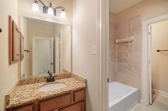 a bathroom with a granite countertop sink and a mirror