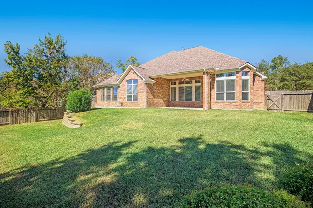 a view of a house with a big yard and large trees