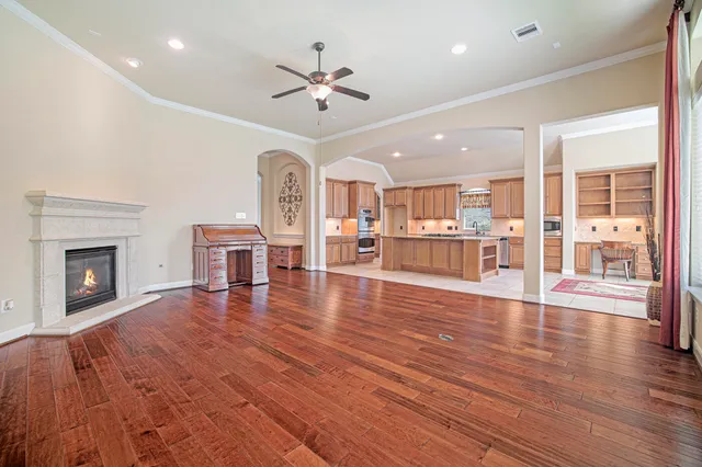 a view of a room with wooden floor and a kitchen