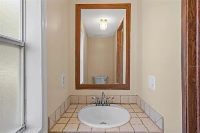 a bathroom with a granite countertop sink and a mirror