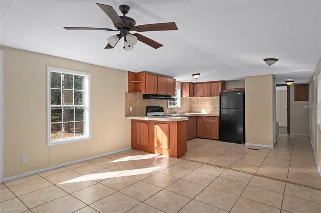 a kitchen with granite countertop a refrigerator and a stove top oven