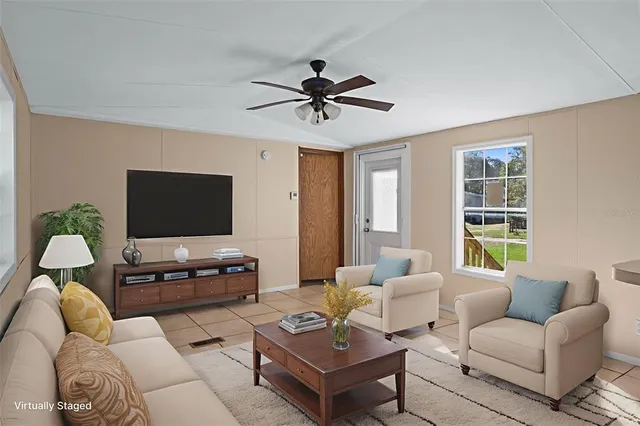 a living room with furniture a flat screen tv and a window