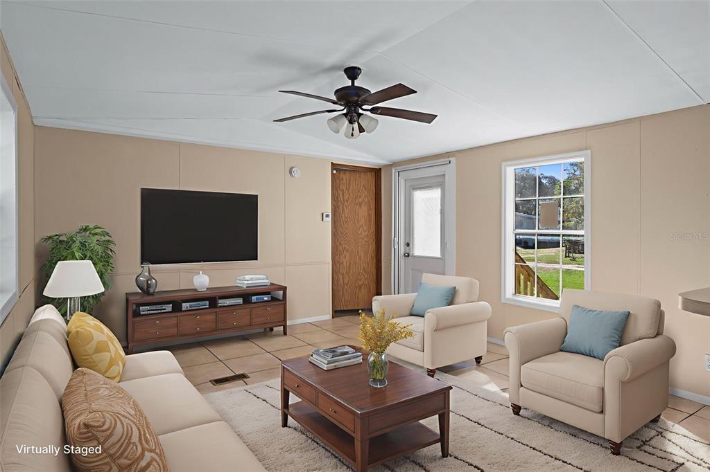 4939 West Foxhill Lane Homosassa, FL 34446 - Photo 7 of 37 a living room with furniture a flat screen tv and a window