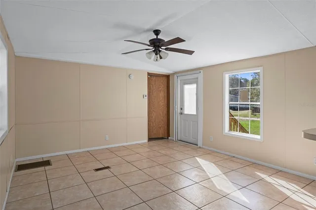 a view of a livingroom with a chandelier fan and windows