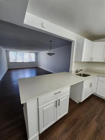 a kitchen with cabinets and wooden floors