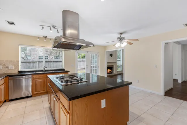 a kitchen with stainless steel appliances granite countertop a sink a stove and a refrigerator