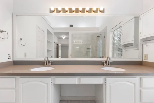 a bathroom with double sink and a mirror