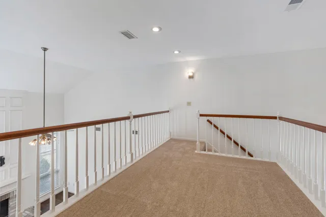 a view of staircase with railing and white walls
