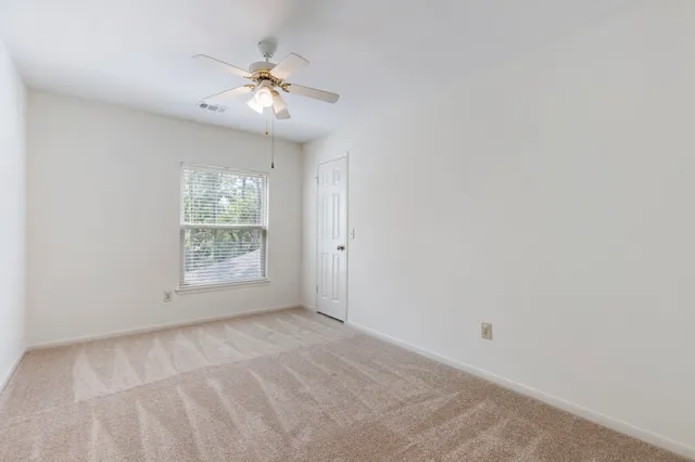an empty room with fan and window