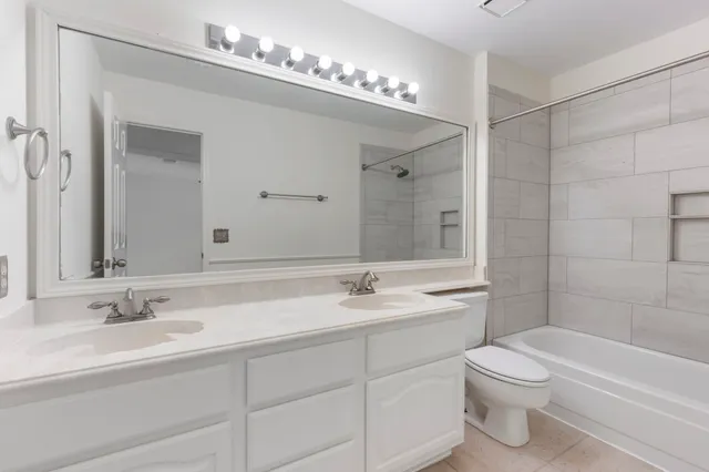a bathroom with a sink a toilet and a large mirror
