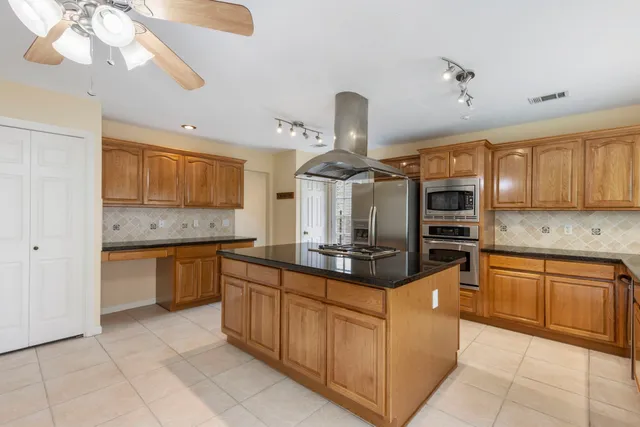 a kitchen with stainless steel appliances granite countertop a sink and a stove