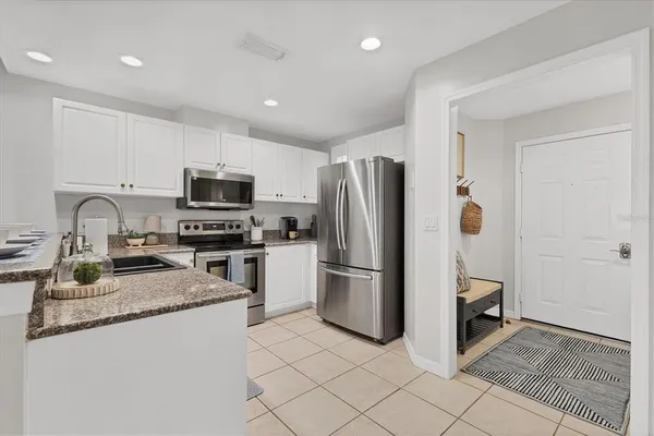 a kitchen with granite countertop a refrigerator and a sink