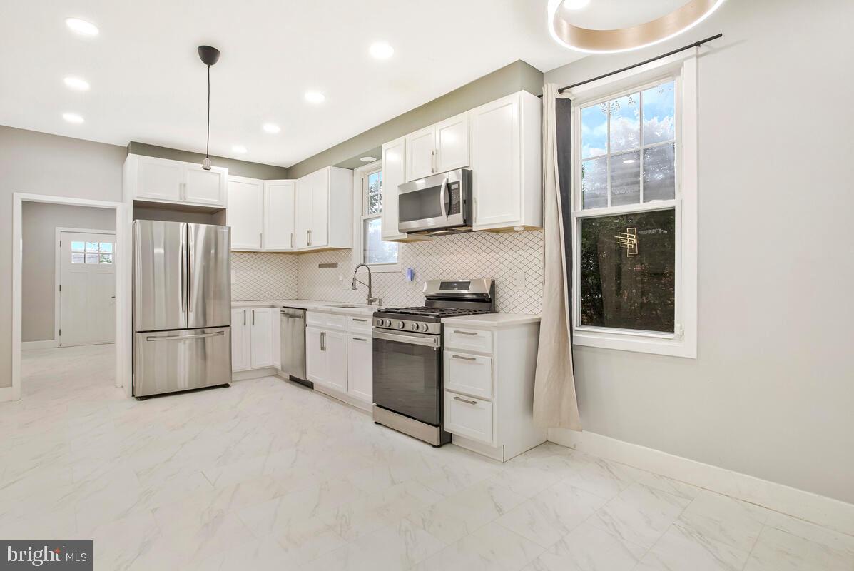6204 Everall Avenue Baltimore, MD 21206 - Photo 8 of 34 a kitchen with stainless steel appliances white cabinets and a refrigerator