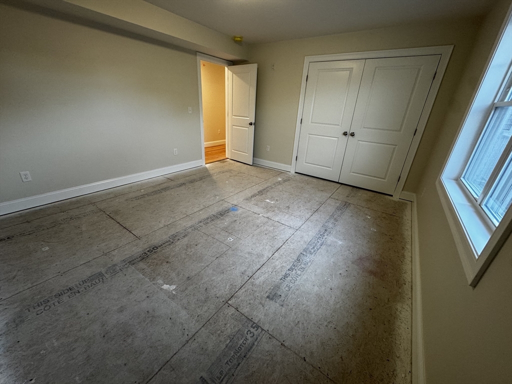 78 Arlington Street, Unit 2 Taunton, MA 02780 - Photo 12 of 28 an empty room with wooden floor and windows
