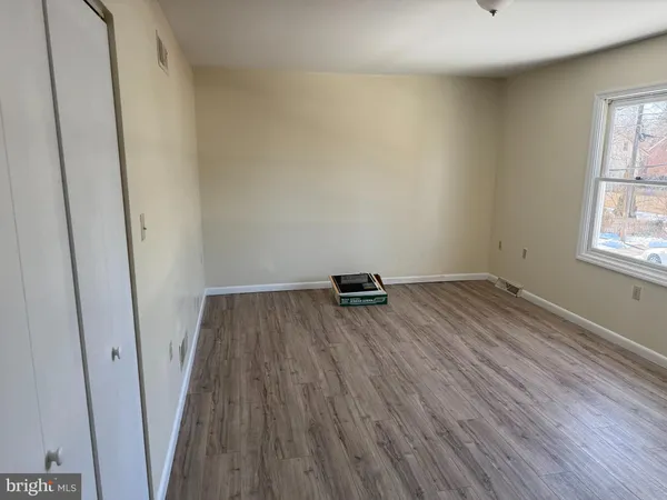 a view of a room with wooden floor and a window