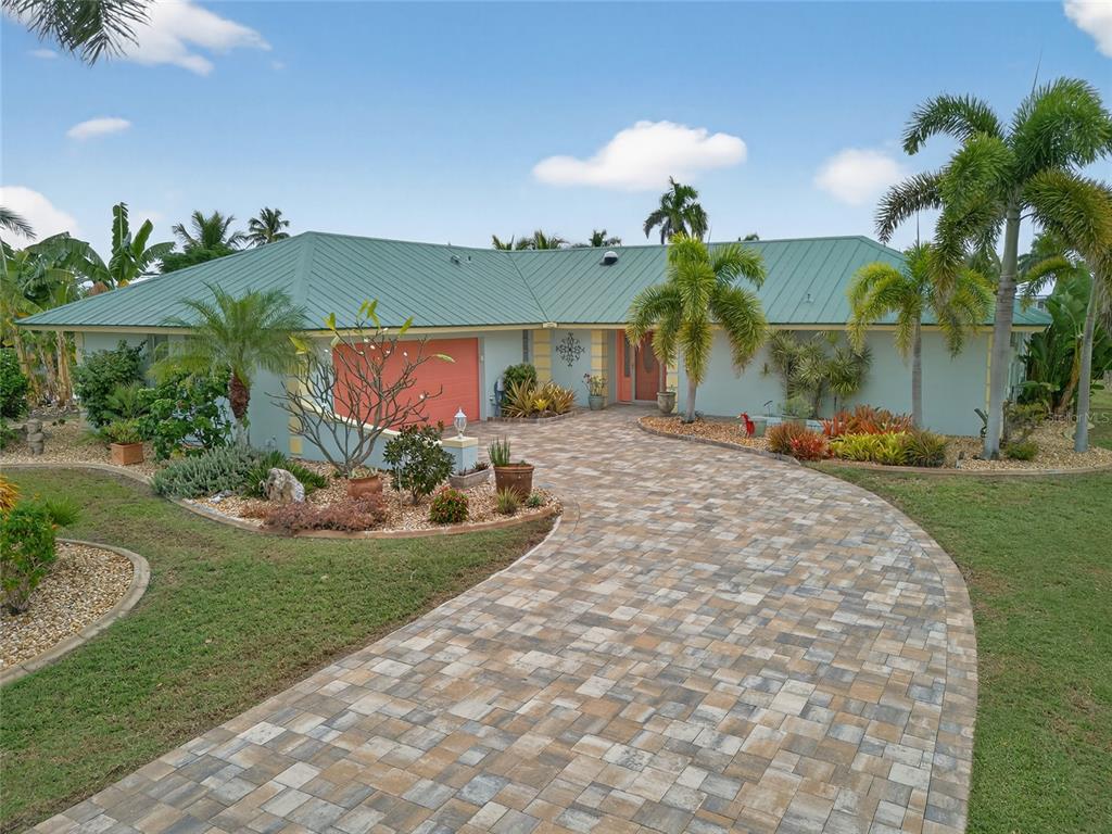 a front view of a house with a yard and potted plants