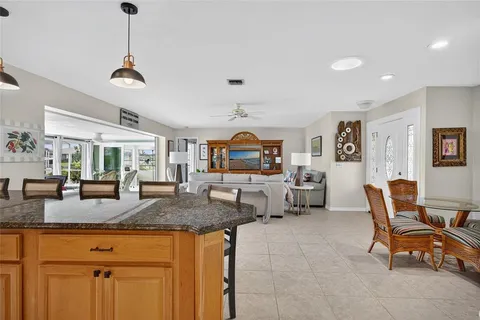 a living room with granite countertop furniture a dining table and chairs with wooden floor