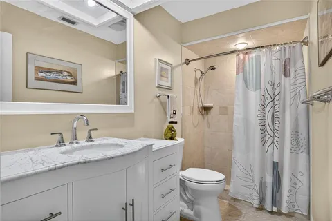 a bathroom with a granite countertop sink toilet and shower