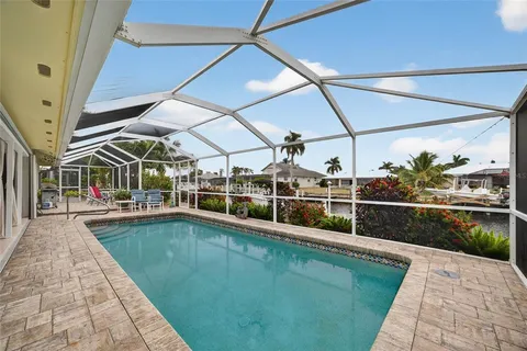 a view of a swimming pool with a patio and a yard