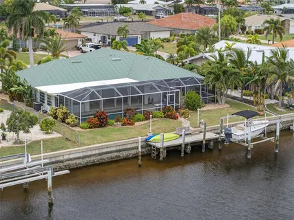 an aerial view of a house with swimming pool and outdoor seating