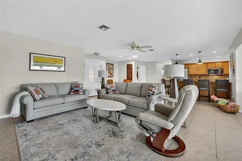 a living room with furniture and a view of kitchen