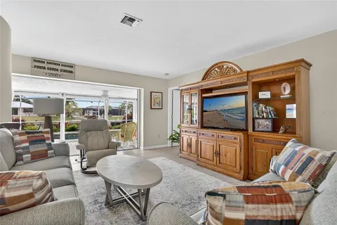 a living room with furniture a window and a flat screen tv