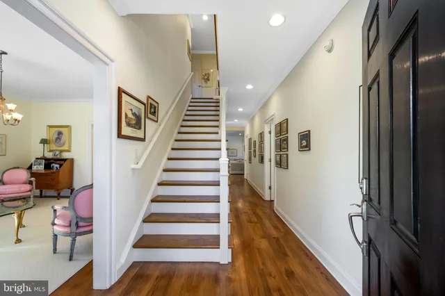 a kitchen with stainless steel appliances granite countertop a stove top oven a sink dishwasher a dining table and chairs with wooden floor