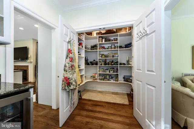 a view of a hallway with living room and wooden floor