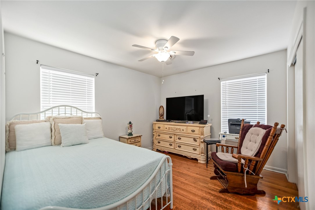 207 Williams Street Tivoli, TX 77990 - Photo 22 of 32 a bedroom with a bed and a flat screen tv with wooden floor