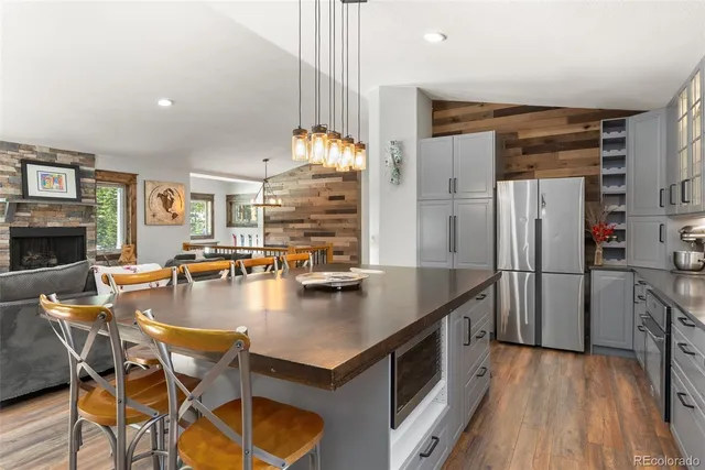 a kitchen with stainless steel appliances granite countertop a refrigerator a stove and a wooden floors