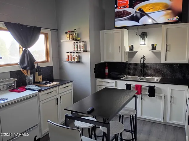 a kitchen with stainless steel appliances a stove a table and chairs