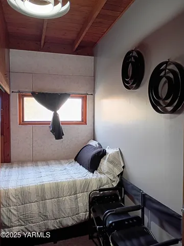 a bedroom with a bed and a lamp on the dresser