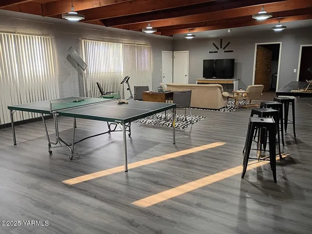 a living room with furniture a wooden floor and a flat screen tv
