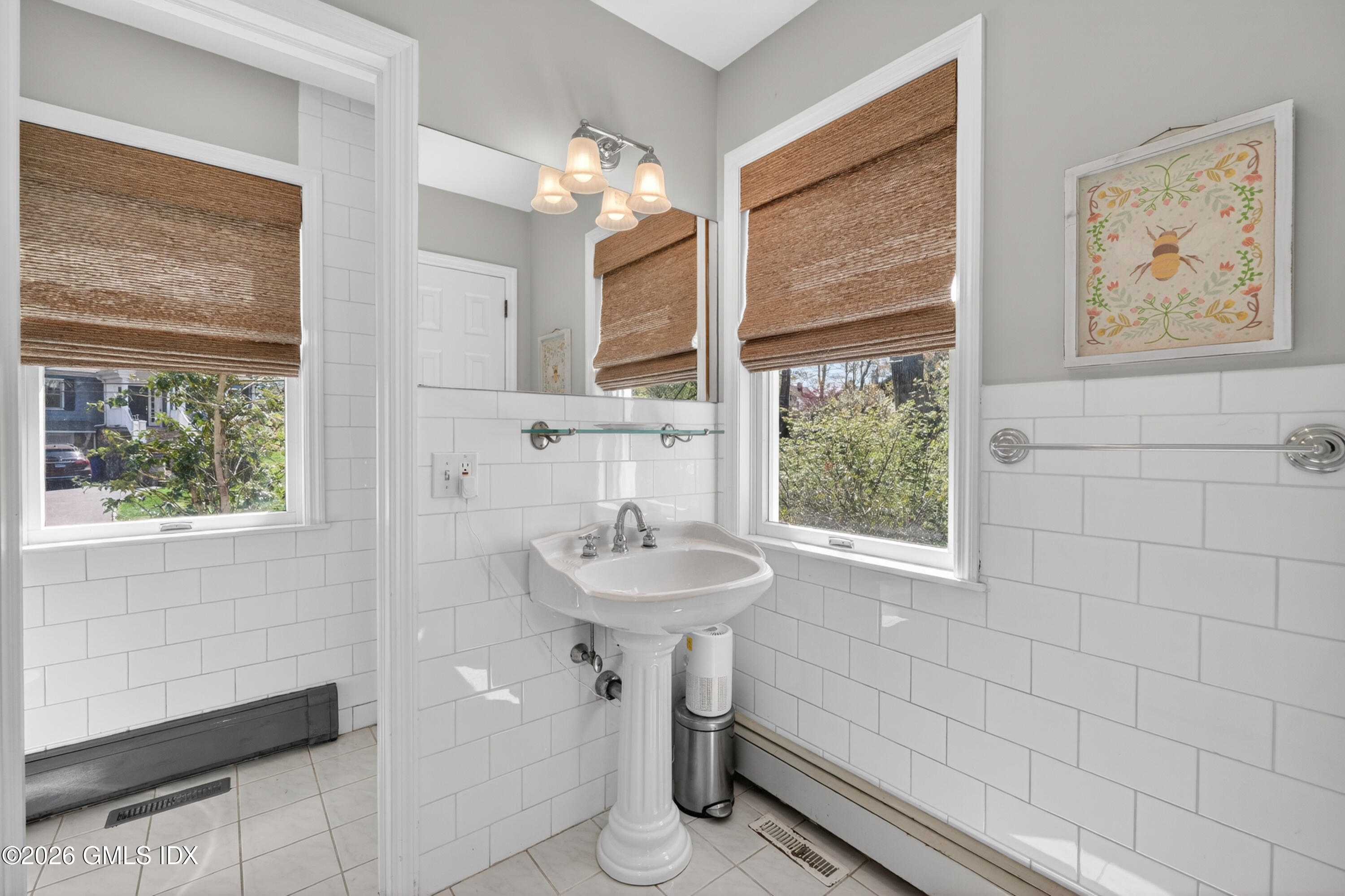 20 Ridge Road Cos Cob, CT 06807 - Photo 20 of 36 a bathroom with a sink a mirror a window and a shower